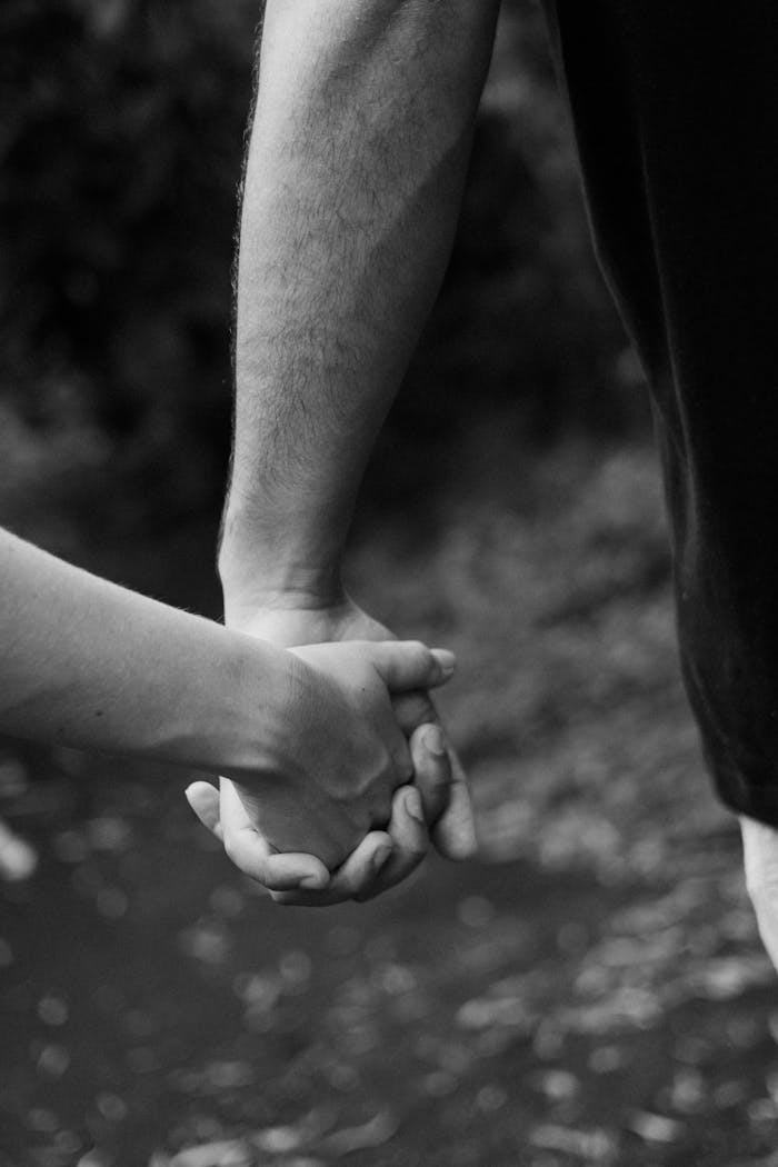 Close-up of a couple holding hands, symbolizing love and connection.